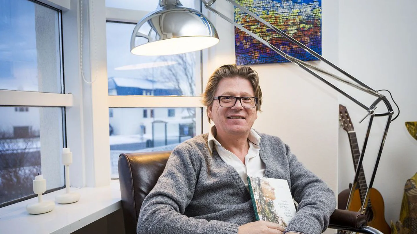 Eiríkur Bergmann situr með bók á ljósmynd sem birtist árið 2017